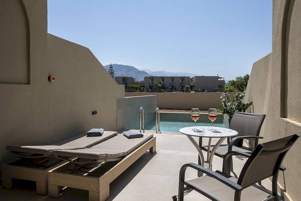 Terrasse mit Liegen, Tisch und zwei Weingläsern im Vantaris Resort.