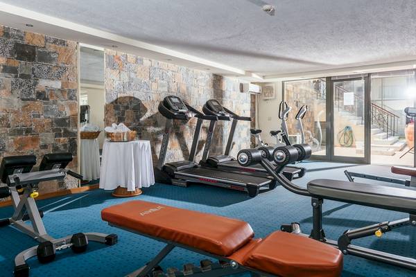 Fitnessraum im Arina Beach Resort mit Laufbändern, Hantelbank und Hanteln.