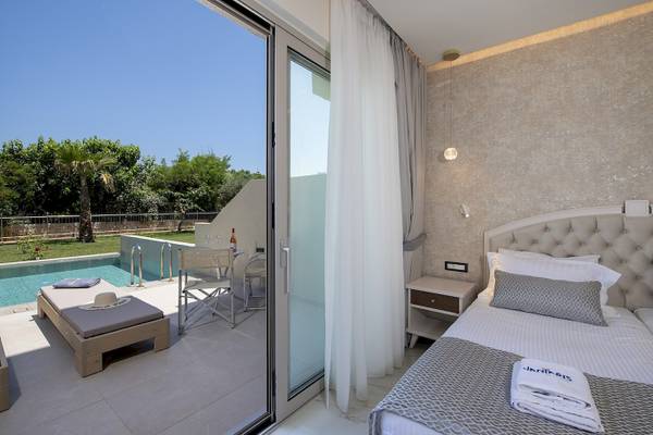 Zimmer mit Terrasse im Vantaris Luxury Beach Resort, mit Blick auf den Pool.