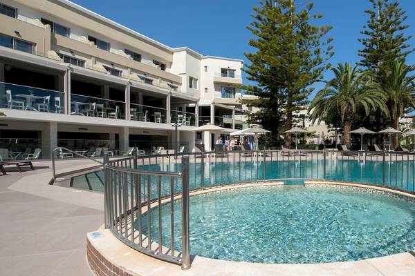 Vantaris Luxury Beach Resort Pool mit umlaufendem Geländer und Sonnenschirmen.