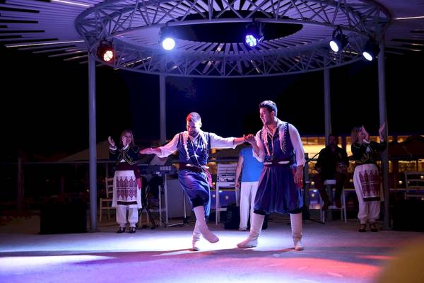 Zwei Männer tanzen in traditioneller Kleidung auf der Bühne des Arina Beach Resorts.