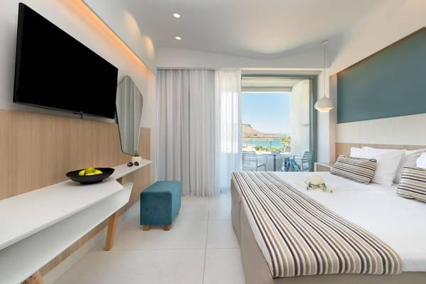 Innenansicht eines Hotelzimmers im Arina Beach Resort mit Fernseher, Balkon und Meerblick.