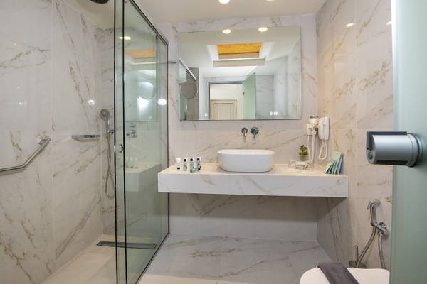 Badezimmer im Vantaris Luxury Beach Resort mit Marmorfliesen und moderner Einrichtung.