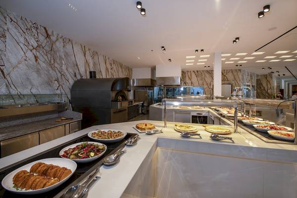 Innenansicht des Restaurants im Vantaris Luxury Beach Resort mit Speisen und Küchengeräten.