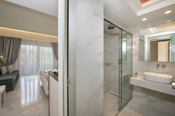 Vantaris Luxury Beach Resort Badezimmer mit Dusche und Waschbecken.