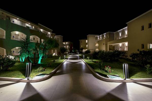 Nachtansicht des Vantaris Luxury Beach Resorts mit beleuchteten Gebäuden und gepflegtem Garten.