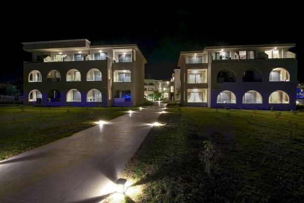 Nachtansicht des Vantaris Luxury Beach Resorts mit beleuchteten Wegen und Gebäuden.