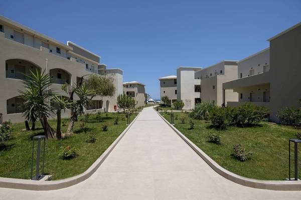 Eingangsbereich des Vantaris Luxury Beach Resort mit gepflegten Rasen und Gehweg.
