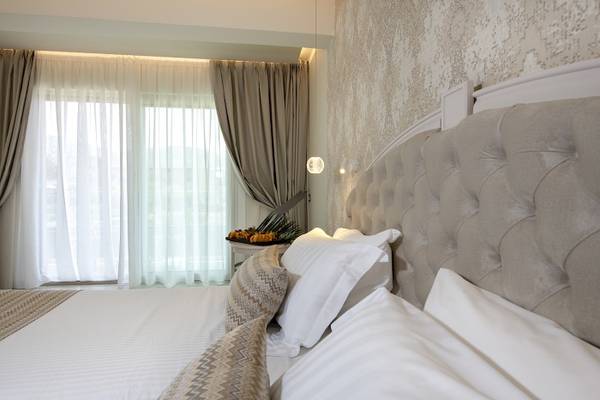 Hotelzimmer im Vantaris Luxury Beach Resort mit Bett, Kissen und Deko.