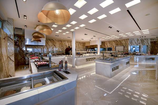 Vantaris Luxury Beach Resort Speisebereich mit Marmorwänden, modernen Leuchten und verschiedenen Essensstationen.
