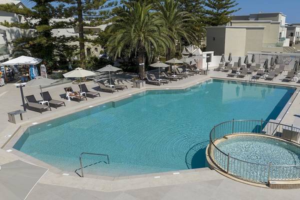 Außenbereich des Vantaris Luxury Beach Resort mit Swimmingpool und Sonnenliegen.