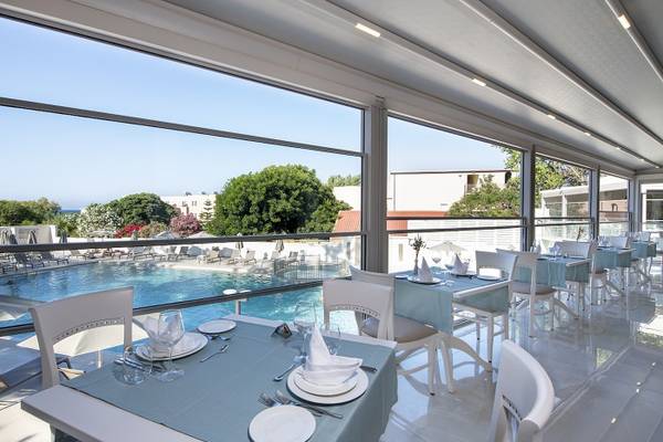 Innenansicht des Restaurants im Vantaris Luxury Beach Resort mit Blick auf den Pool.