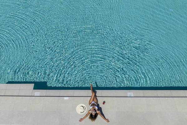 Person am Rand des Infinity-Pools im Vantaris Luxury Beach Resort