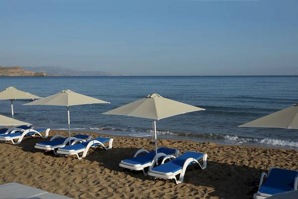 Arena Strand mit Lounge-Stuhlreihen unter Sonnenschirmen am Meer