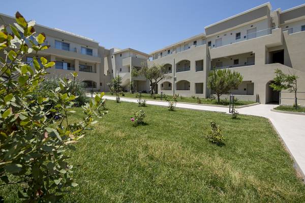 Außenbereich des Vantaris Luxury Beach Resorts mit gepflegtem Rasen und Gebäuden.