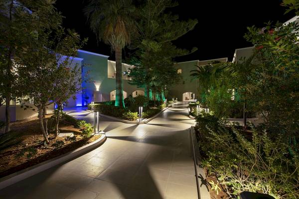 Außenbereich des Vantaris Luxury Beach Resort bei Nacht mit beleuchteten Wegen und Pflanzen.