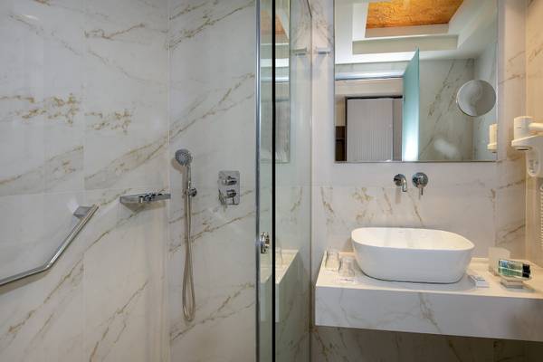 Das Badezimmer von Vantaris Luxury Beach Resort mit weißen Marmorwänden und einer Dusche.