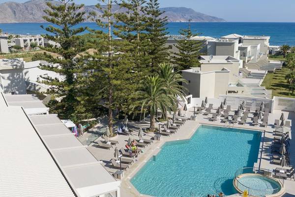 Luftaufnahme des Poolbereichs des Vantaris Luxury Beach Resort mit blauem Wasser und weißen Gebäuden.