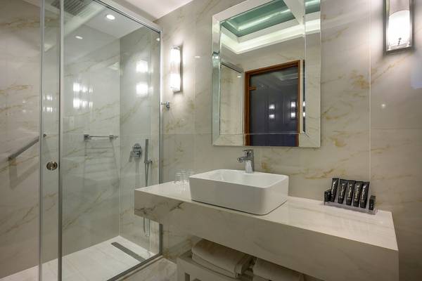 Badezimmer im Vantaris Palace Hotel mit Marmorboden und weißen Fliesen.