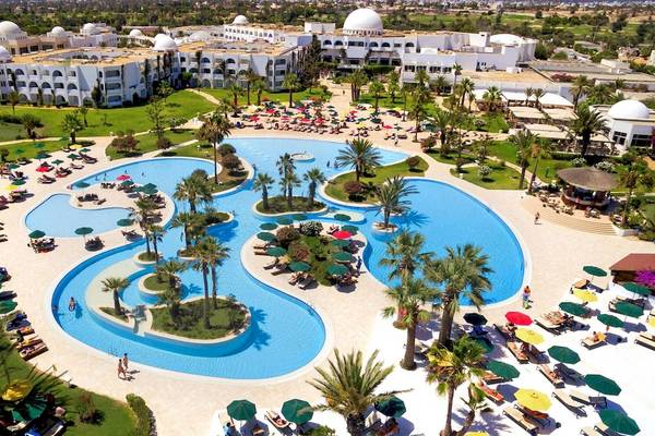 Luftaufnahme des Djerba Plaza Thalasso & Spa Hotels mit großem Pool und vielen Gästen.