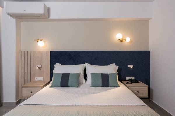 Hotelzimmer im Vantaris Palace mit Bett, Kopfteil, Nachttischen und Klimaanlage