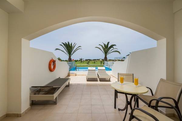 Terrasse des Vantaris Palace mit Blick auf den Pool und Palmen.