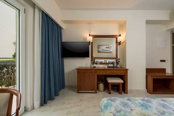 Hotelzimmer des Vantaris Palace mit Bett, Schreibtisch, Fernseher und Aussicht.
