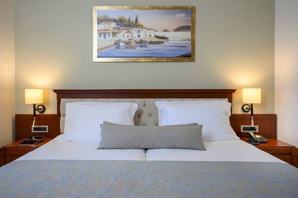 Bett im Vantaris Palace Hotelzimmer mit Dekor und Gemälde an der Wand