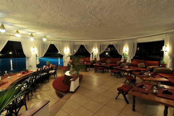 Innenbereich des Southern Palms Beach Resorts mit Blick auf den Pool, mit roten Sofas, Tischen und Pflanzen.