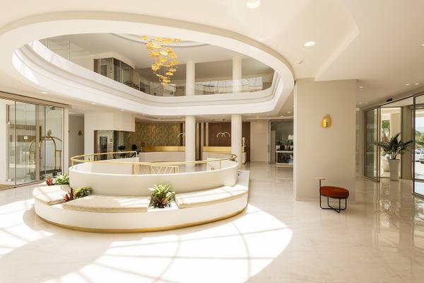 Vantaris Palace Lobby mit zentraler Sitzbank, goldenem Geländer und hängenden Lampen.