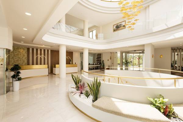 Innenansicht des Vantaris Palace Hotels mit einer weißen Marmorlobby und goldenen Details.