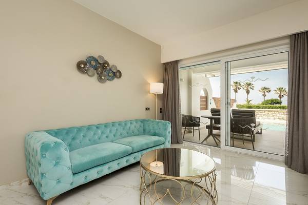 Wohnzimmer im Vantaris Palace mit blauem Sofa und goldfarbenem Tisch.