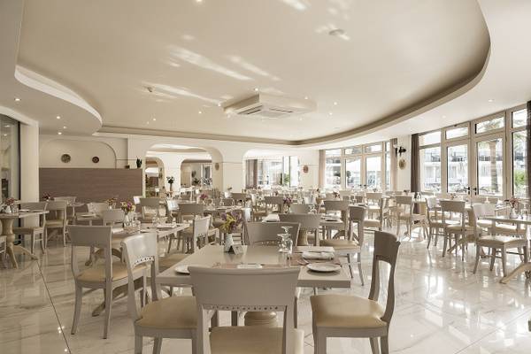 Innenansicht des Restaurants im Vantaris Palace mit vielen gedeckten Tischen und Stühlen.