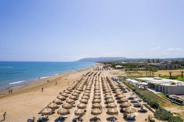 Luftaufnahme des Vantaris Palace Strandes mit vielen Sonnenschirmen und Gästen.