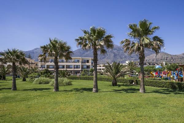 Außenbereich des Vantaris Palace Hotels mit Palmen und Spielplatz.