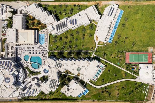 Luftaufnahme des Vantaris Palace Hotels mit mehreren Swimmingpools, Tennisplatz und gepflegtem Rasen.