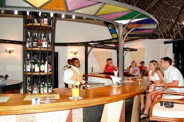 Bar im Southern Palms Beach Resort mit bunter Beleuchtung und Menschen, die sitzen und trinken.