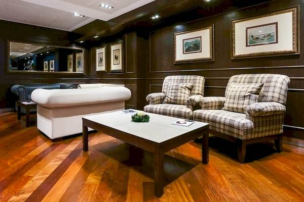 Lobby im Colonial Barcelona Hotel mit weißen Sofas, einem Tisch und Gemälden an der Wand.
