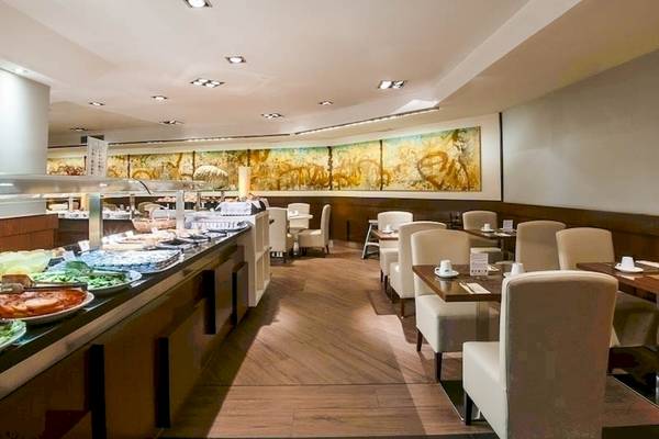 Innenansicht des Restaurants im Colonial Barcelona Hotel mit Buffet und Tischen.