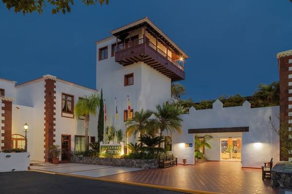 Außenansicht des Jardin Tecina Hotels bei Nacht mit beleuchteter Fassade und Eingangsbereich.