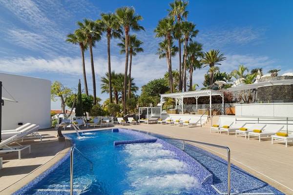 Poolbereich des Jardin Tecina Hotels mit vielen Liegestühlen und Palmen