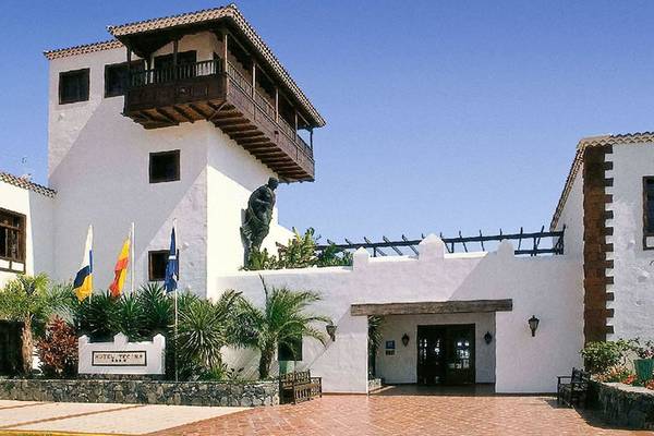 Das Jardin Tecina Hotel mit einer Statue, Flaggen und einem gepflasterten Eingangsbereich.