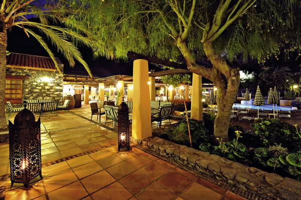 Außenterrasse des Jardin Tecina Hotels bei Nacht mit beleuchteten Möbeln und Bäumen.