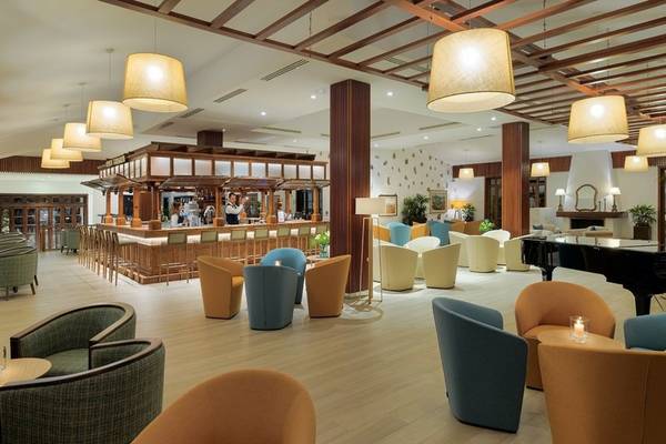 Innenbereich des Jardin Tecina Hotels mit Bar, Sitzbereichen und Klavier.