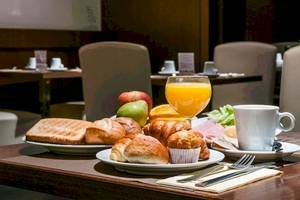 Frühstücksbuffet im Colonial Barcelona mit Brot, Brötchen, Obst, Saft und Kaffee.