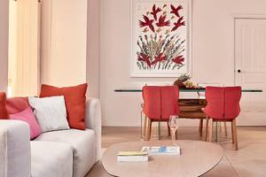 Wohnbereich im Myconian Ambassador Hotel mit Couch, Tisch und Kunstwerk.