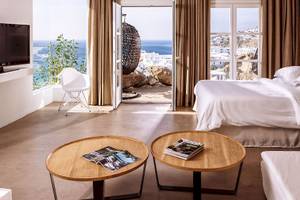 Hotelzimmer im Myconian Ambassador Relais & Chateaux mit Meerblick und modernen Möbeln.