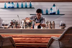 Barkeeper im Myconian Ambassador Hotel schenkt einen Drink ein.