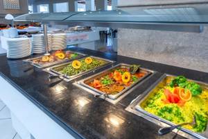 Buffet-Tisch im Djerba Holiday Beach Hotel mit verschiedenen Gerichten und Früchten.