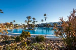 Außenbereich des Djerba Holiday Beach Hotels mit Swimmingpool, Palmen und Gebäuden